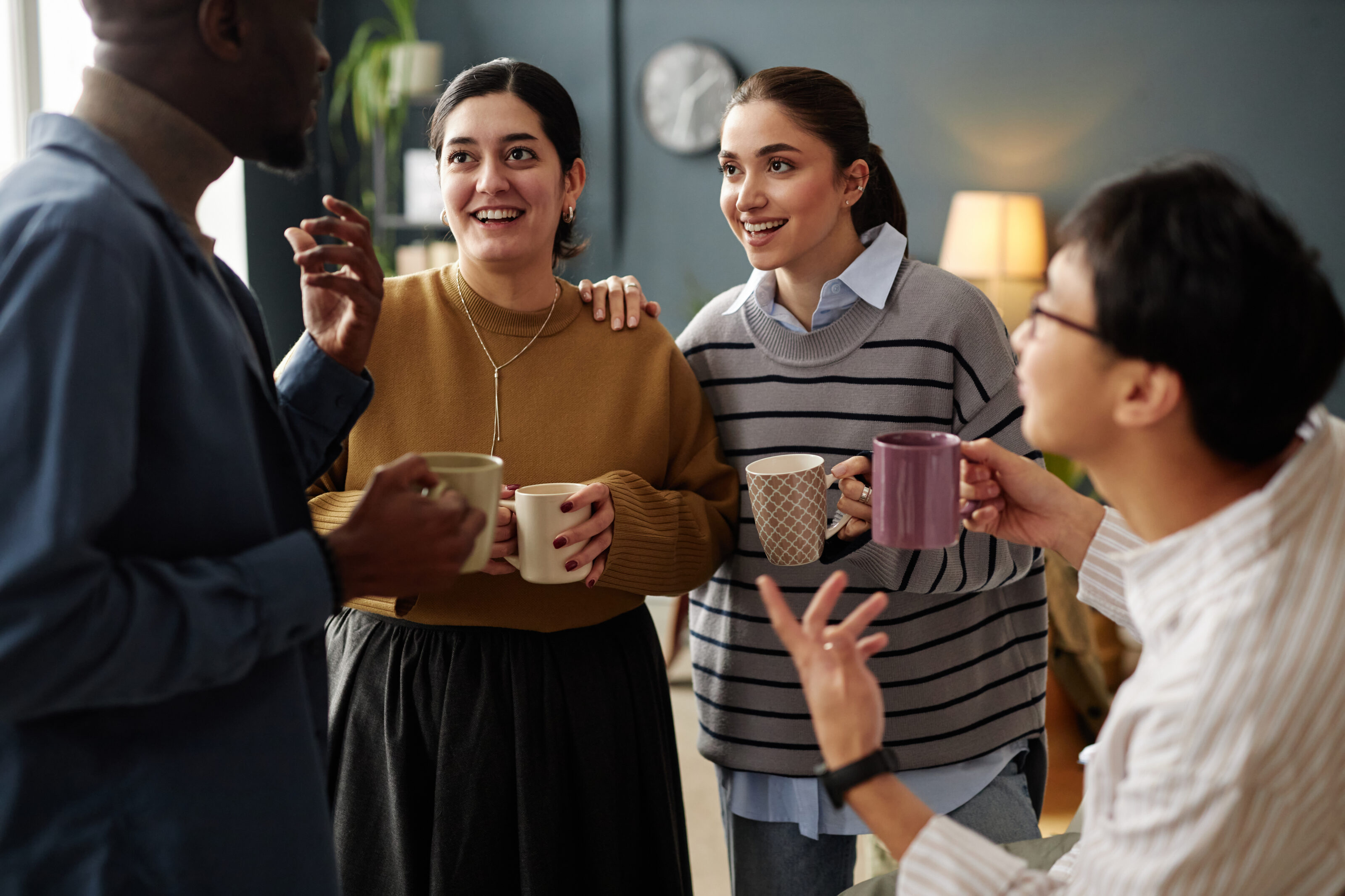 Colleagues standing and smiling with coffee