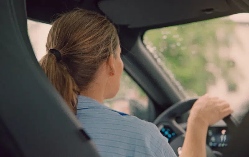 View of woman driving electric car